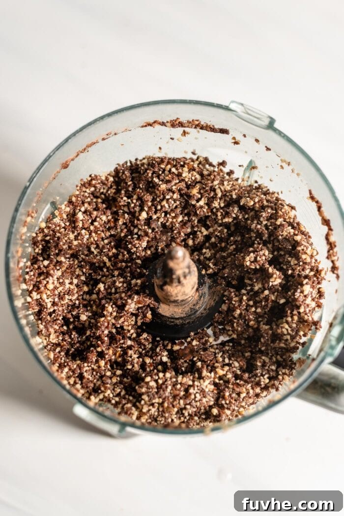 Blended chocolate brownie dough in a food processor, forming a cohesive ball.