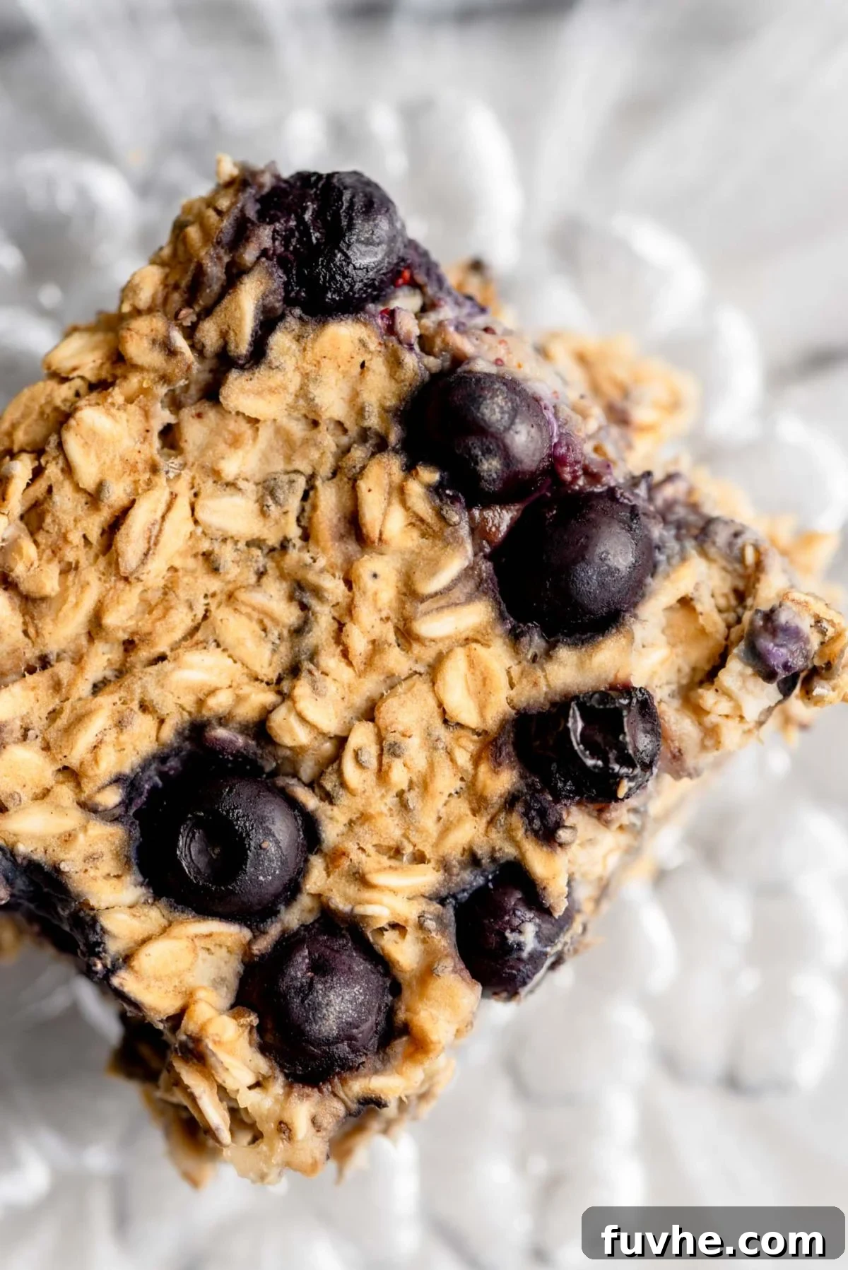 Protein-Packed Baked Oats 8 A perfectly sliced piece of protein baked oatmeal with visible blueberries, served on a small glass plate.