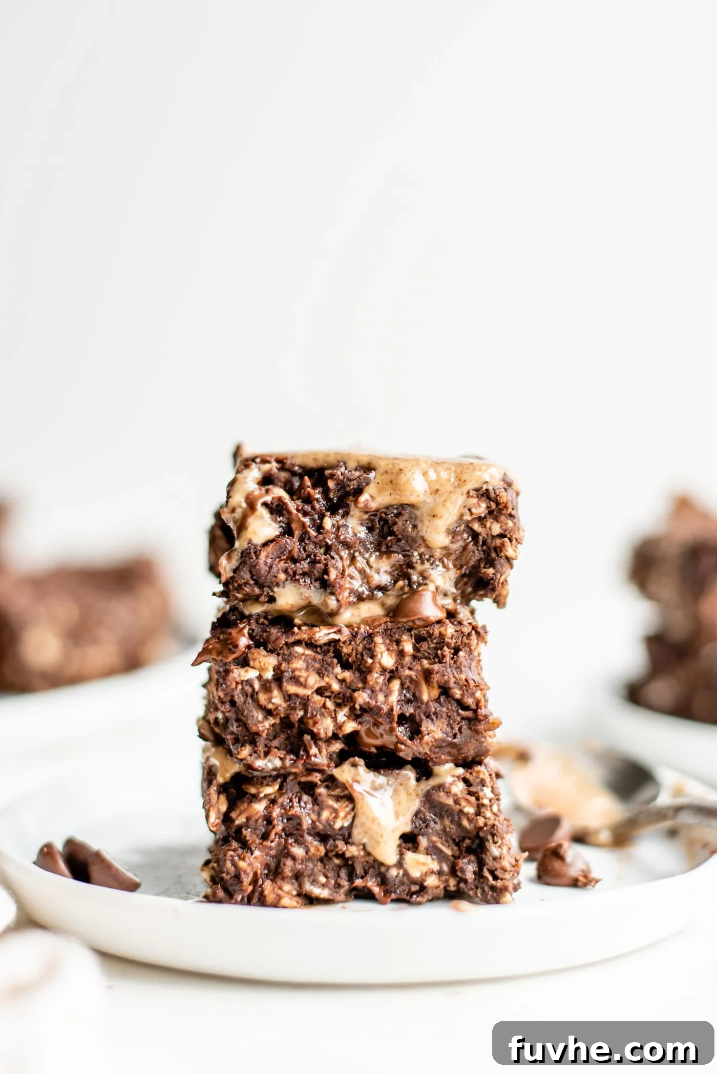 Wholesome Chocolate Protein Baked Oat Bars 2 Stack of 3 baked double chocolate chip oatmeal bars on a plate, ready to be enjoyed as a healthy vegan snack or dessert.
