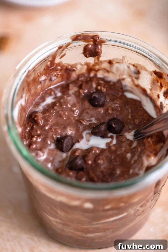 Jar of overnight chocolate protein oats with a few chocolate chips sprinkled over top.