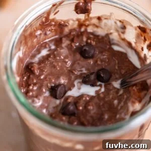 Jar of overnight chocolate protein oats with a few chocolate chips sprinkled over top.