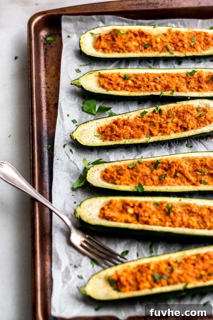 Easy Vegan Chickpea Stuffed Zucchini Boats on a baking tray.