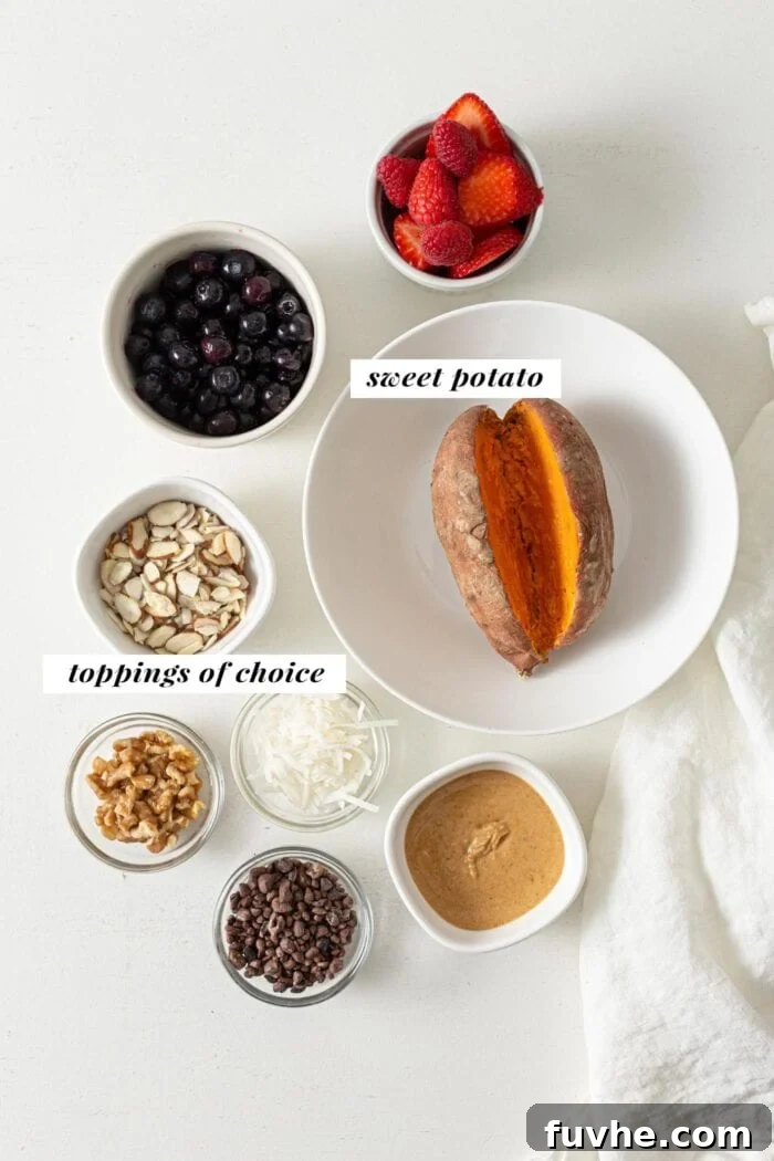 Overhead view of sweet potato, peanut butter, berries, coconut, cacao nibs and almonds in small dishes.