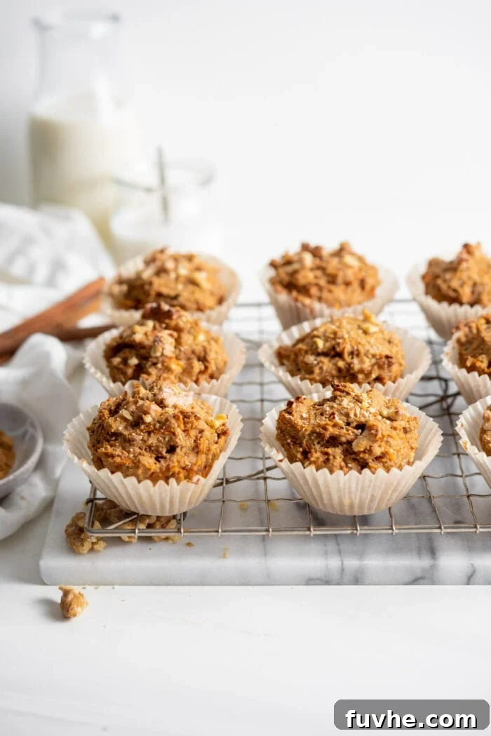 Carrot muffins in muffin liners cooling on a cooling rack.