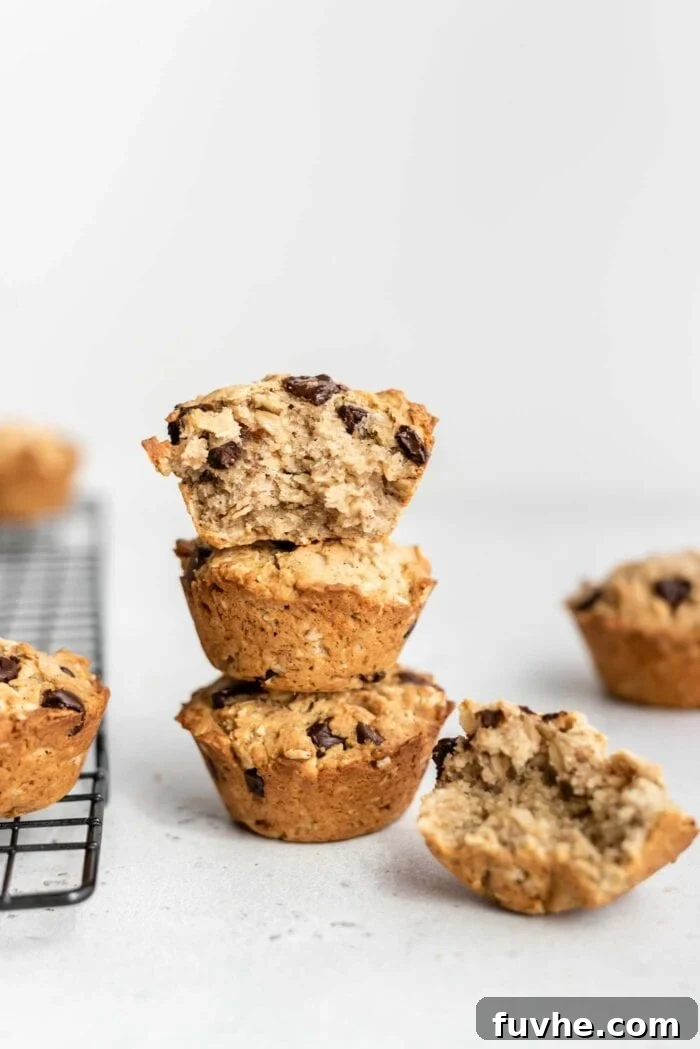 A stack of 3 chocolate chip muffins with a bite taken out of the one on top.