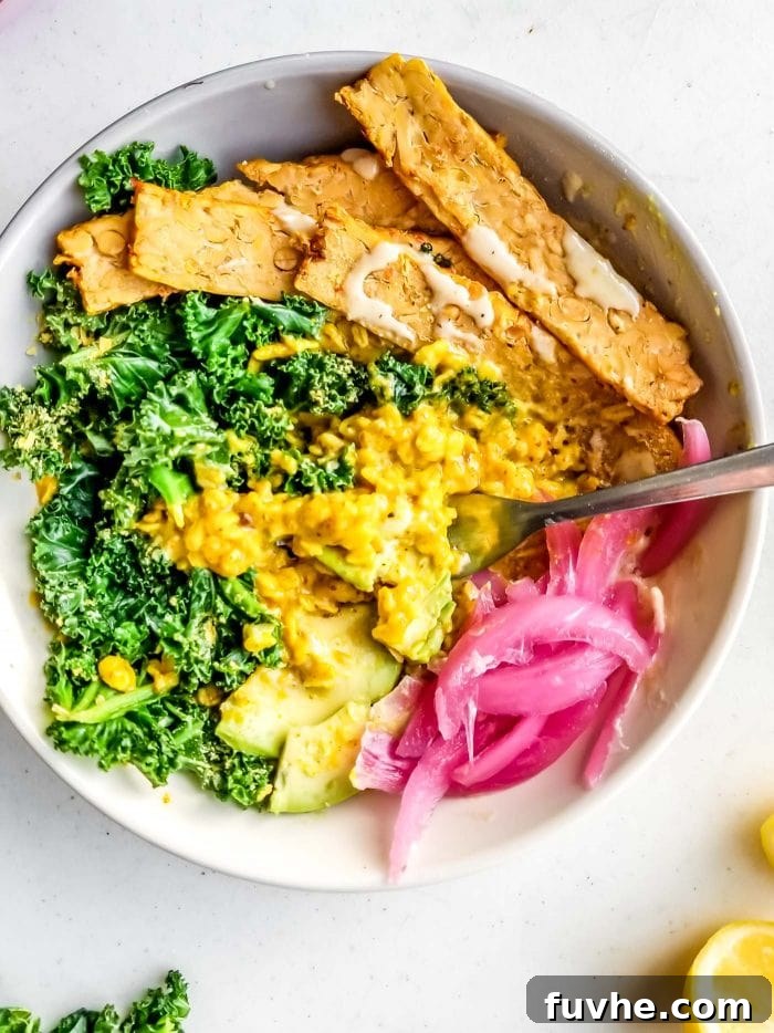 A bowl of savory oatmeal with pickled onion, tempeh and kale.