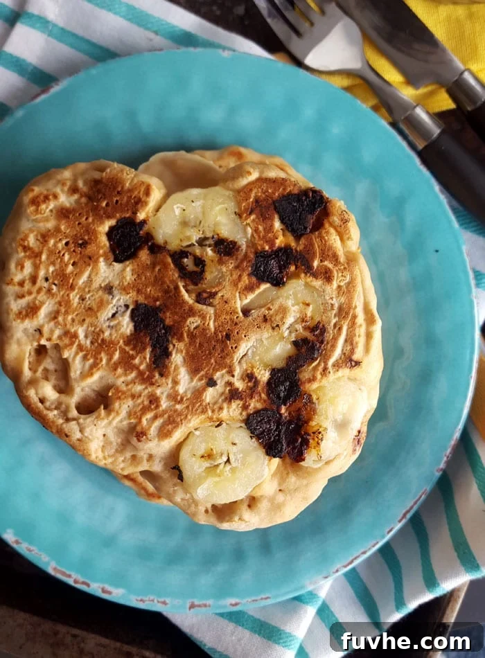 Plant-Based Campfire Cuisine 4 A stack of perfectly golden, fluffy vegan pancakes adorned with fresh berries and maple syrup, ready for a delicious camping breakfast.