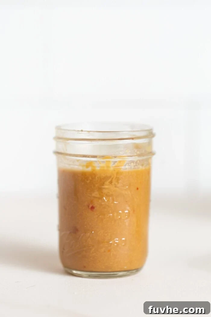 A small jar of peanut sauce sitting on a counter.