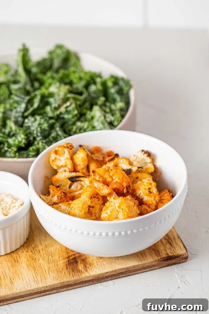 Crispy Buffalo Cauliflower Kale Salad 8 A close-up shot of crispy, golden-brown buffalo cauliflower florets, freshly baked and tossed in a spicy sauce, presented in a ceramic bowl.