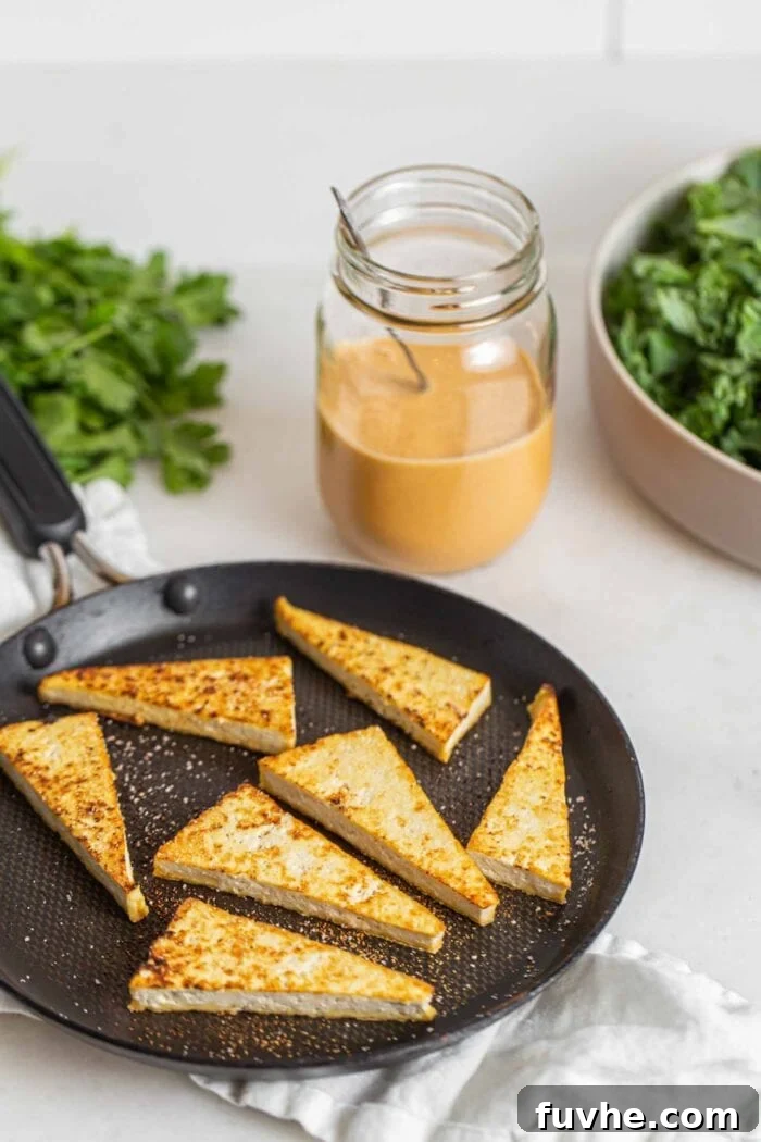 Browned tofu triangles in a skillet on a counter.