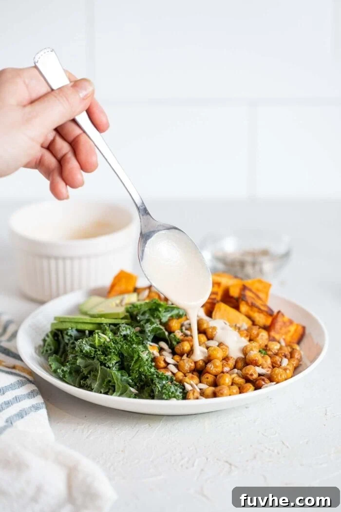 Crispy Roasted Chickpea Kale Salad 9 Drizzling creamy tahini sauce generously over a prepared kale salad.