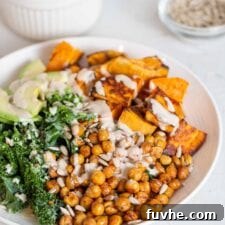 A vibrant kale, roasted chickpea, sweet potato and avocado salad in a bowl.