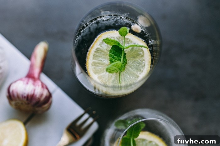 A glass of water next to fresh produce, symbolizing the importance of hydration for energy and anti-inflammatory health.