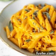 Bowl of creamy pumpkin penne topped with fresh sage.