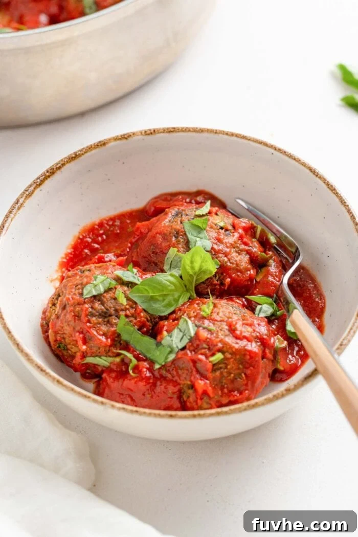 3-Day Plant-Based Whole Food Reset 3 3 lentil meatballs with tomato sauce topped with fresh basil in a bowl.