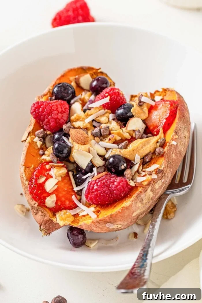 3-Day Plant-Based Whole Food Reset 8 Close up of a baked sweet potato in a bowl topped with berries, almonds, peanut butter and coconut.