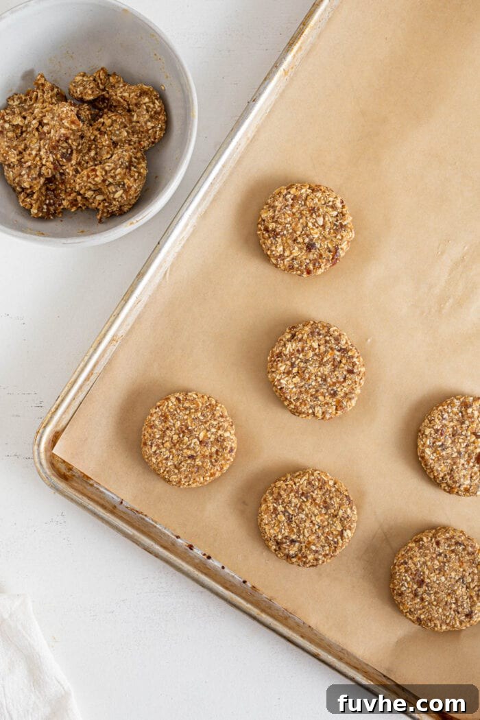 Tahini Date Gems 5 Bowl of cookie dough beside a baking tray of cookies.