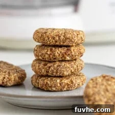 Stack of 4 tahini oat cookies on a plate. 2 cookies rest beside the stack on the plate.