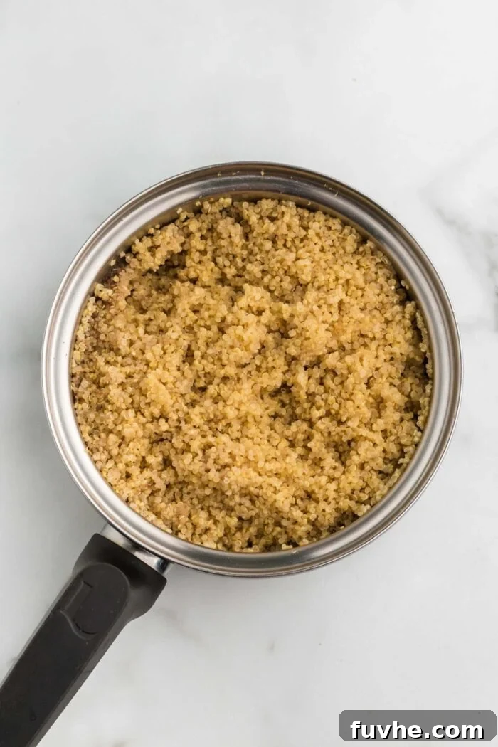 Nourishing Kale Quinoa Chickpea Bowls 5 Perfectly cooked, fluffy quinoa resting in a small pot, ready to be added to the healthy bowls.
