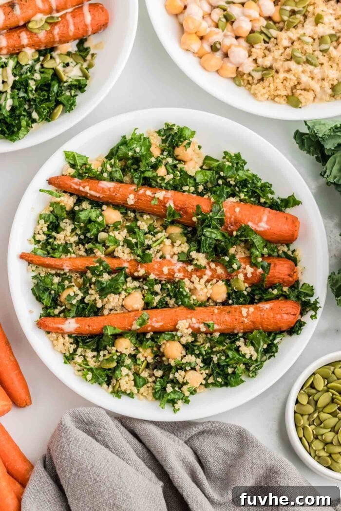 Nourishing Kale Quinoa Chickpea Bowls 9 A beautifully composed kale quinoa chickpea salad, enhanced with roasted carrots, crunchy pumpkin seeds, and a generous drizzle of creamy tahini sauce.