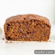 Spiced Vegan Pumpkin Date Loaf 12 Cut open loaf of pumpkin bread with dates in it.