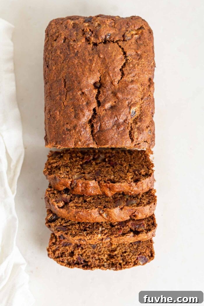 Spiced Vegan Pumpkin Date Loaf 10 An overhead shot of a delicious vegan pumpkin date bread loaf, with one half expertly sliced.