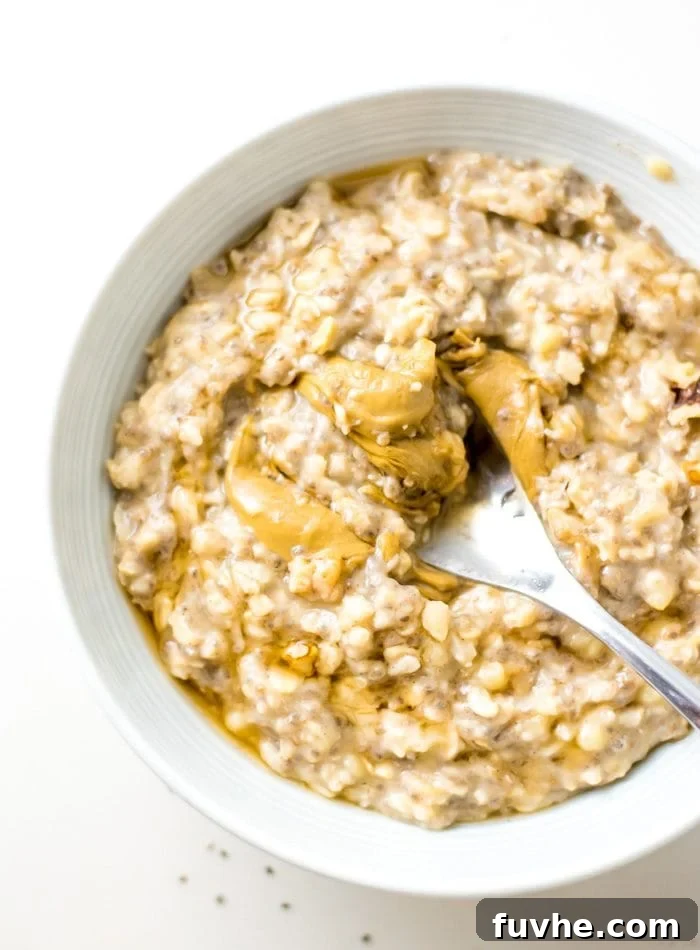 Bowl of banana oatmeal topped with peanut butter. A cozy bowl of banana oatmeal, generously topped with creamy peanut butter, fresh berries, and crunchy seeds, highlighting healthy and delicious porridge toppings.