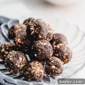 Plate of chocolate date balls coated in pecans.