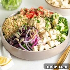 Vibrant Mediterranean Quinoa Bowls 9 A vibrant Mediterranean quinoa bowl with a drizzle of tahini, featuring tofu, fresh vegetables, olives, and hummus.