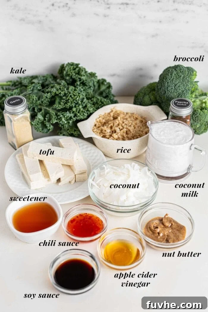 Green Harvest Bowl 3 A selection of fresh ingredients for the bowl: kale, broccoli florets, brown rice, a can of coconut milk, and various bottles of sauces on a kitchen counter.