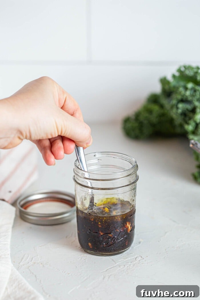 Golden Roasted Squash and Kale Medley 6 Stirring balsamic vinaigrette in a small glass jar.
