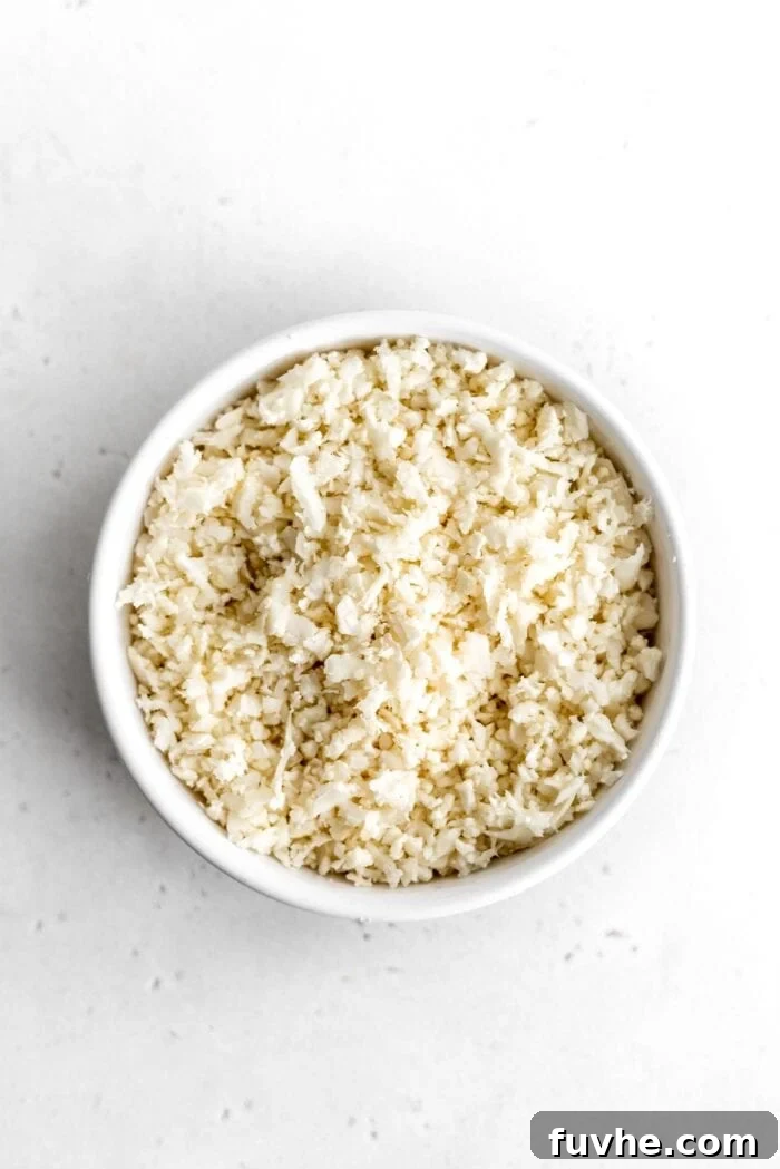Whipping Up Perfect Cauliflower Rice 2 White bowl of cauliflower rice sitting on a white surface.