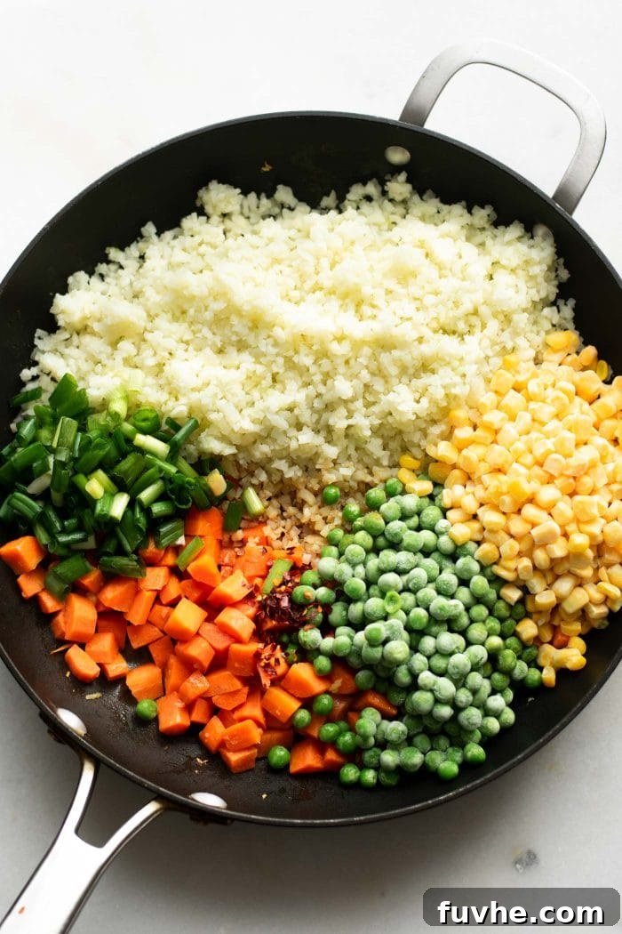 Whipping Up Perfect Cauliflower Rice 6 Riced cauliflower, carrots, peas, corn and green onion in a pan to make cauliflower fried rice.