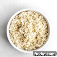 Whipping Up Perfect Cauliflower Rice 8 White bowl of cauliflower rice sitting on a white surface.