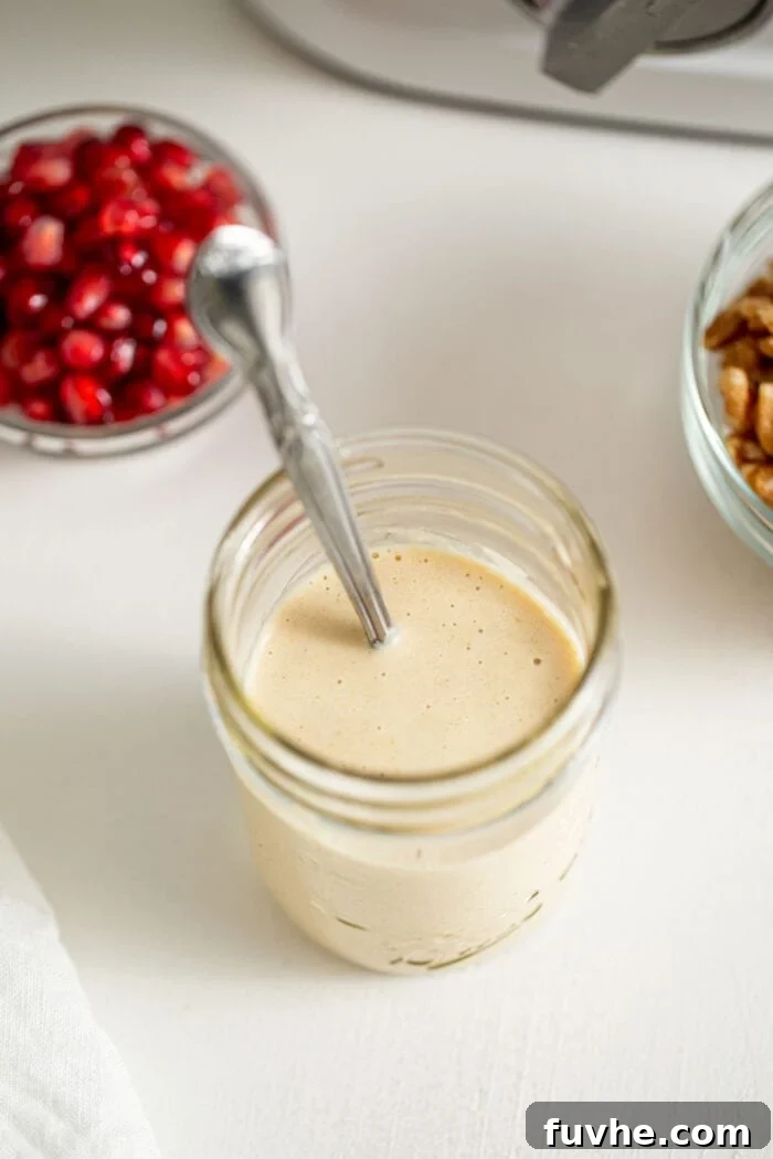 Jar of creamy sauce with a spoon in it.