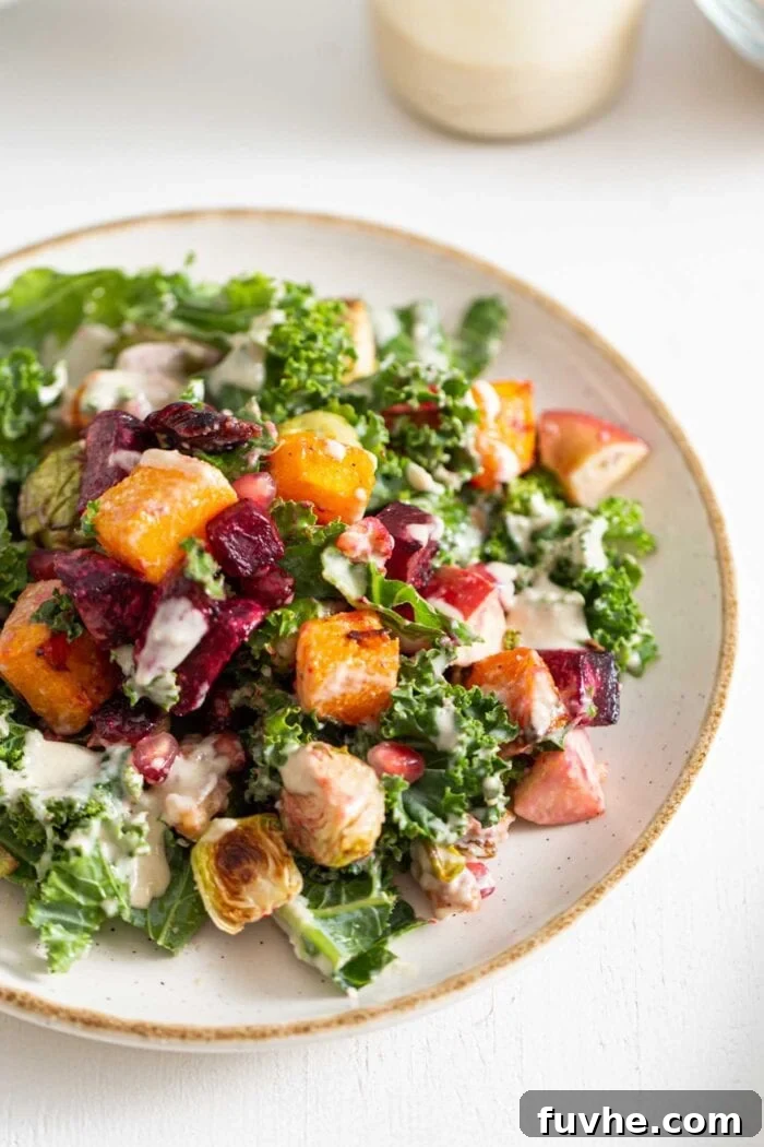 Colourful Fall salad with kale, roasted vegetables and tahini sauce on a plate.