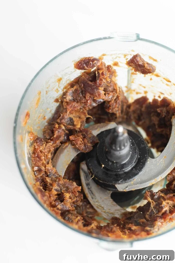 Creamy, blended date paste in a food processor bowl.
