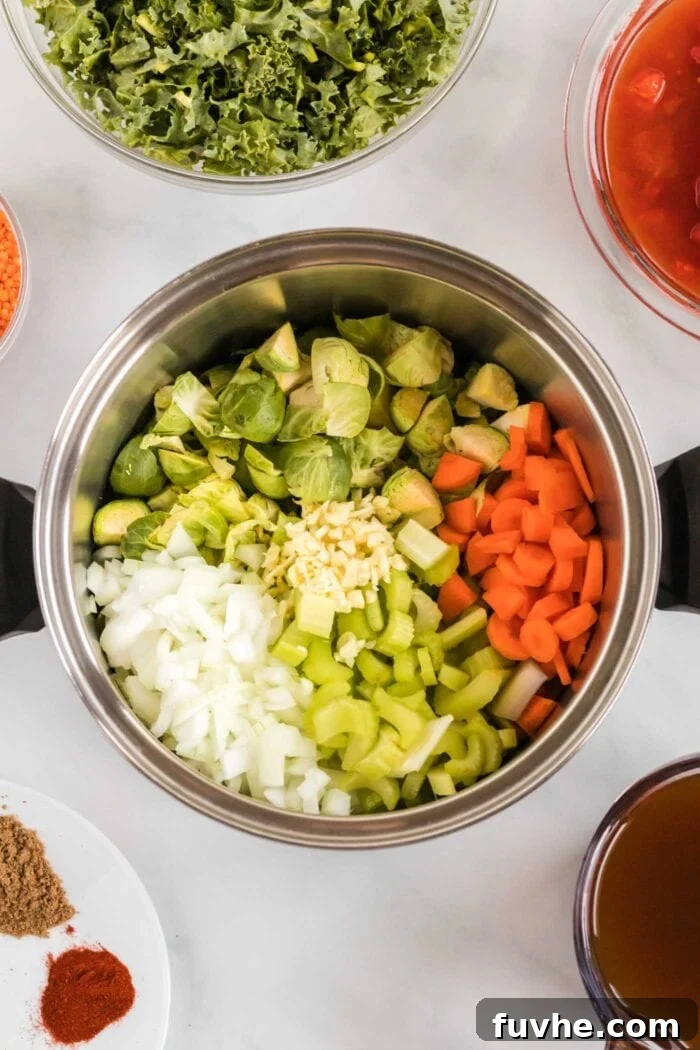 Chopped onion, carrot, celery, garlic, and Brussels sprouts simmering in a large soup pot.