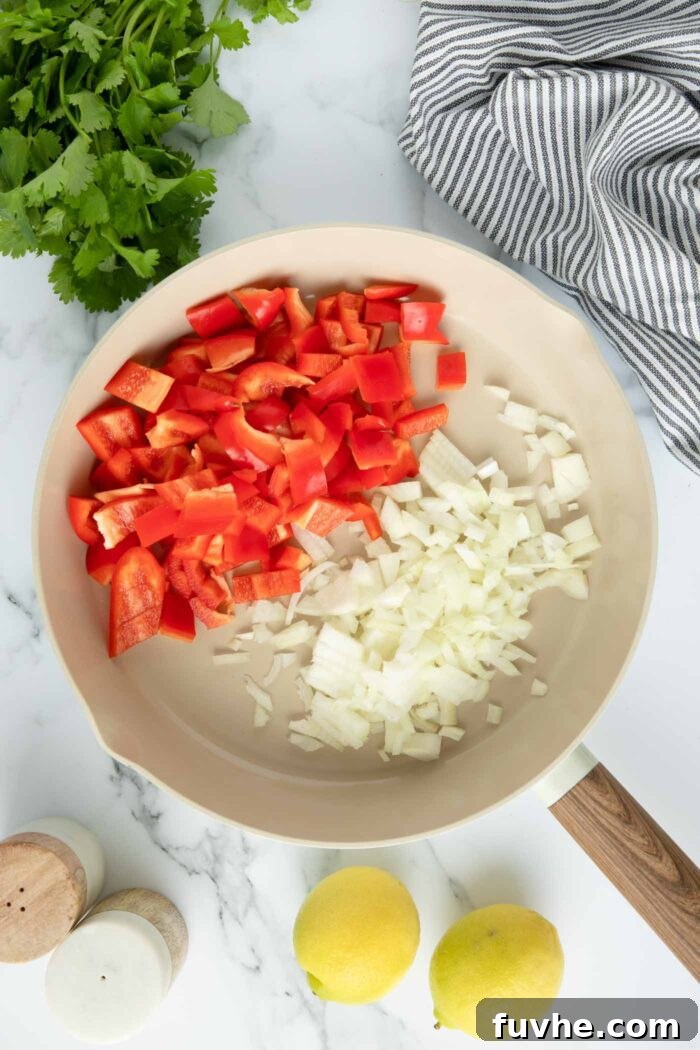 Onion and bell pepper cooking in a skillet.