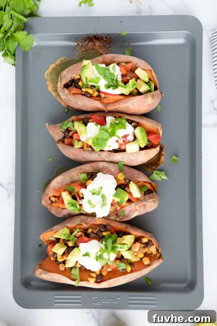 Baked sweet potatoes stuffed with a black bean, red pepper and corn filling and topped with sour cream, avocado and cilantro.