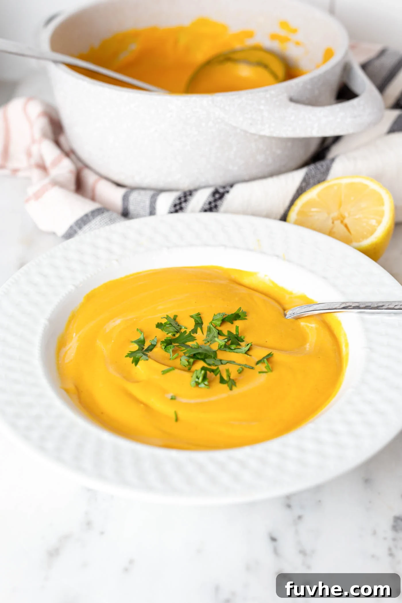 Creamy Golden Cashew Carrot Soup 2 Bowl of creamy vegan cashew carrot soup topped with fresh parsley.