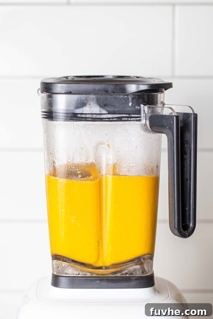 Creamy Golden Cashew Carrot Soup 5 The creamy, blended carrot soup swirling inside a high-speed blender.