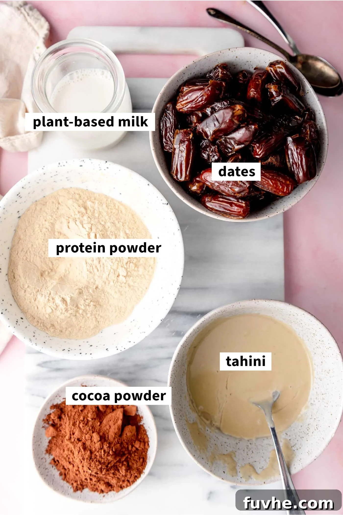 Effortless Chocolate Protein Treats 3 All the ingredients needed for making no-bake chocolate protein bars: tahini, cocoa powder, plant-based milk, dates, and protein powder.