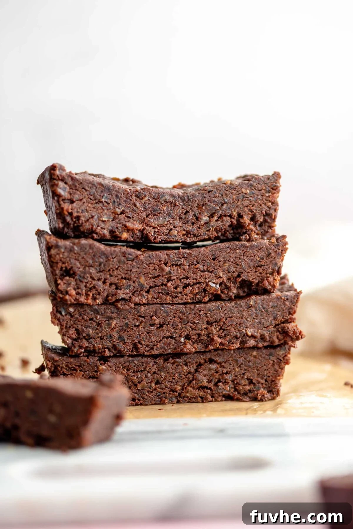 Effortless Chocolate Protein Treats 8 Stack of 4 chocolate protein bars on a marble cutting board.