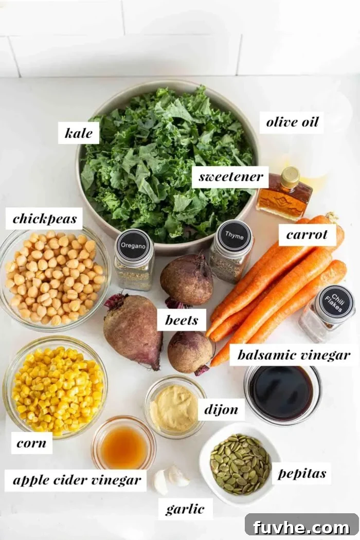 An array of fresh and prepared ingredients for a kale and beet salad, neatly arranged in bowls and containers, including chickpeas, beets, kale, corn, pumpkin seeds, and carrots.