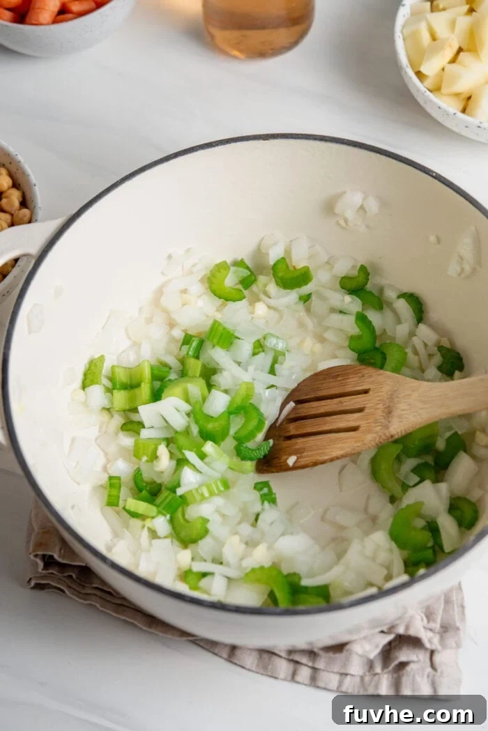 Celery, onion and garlic cooking in a soup pot.