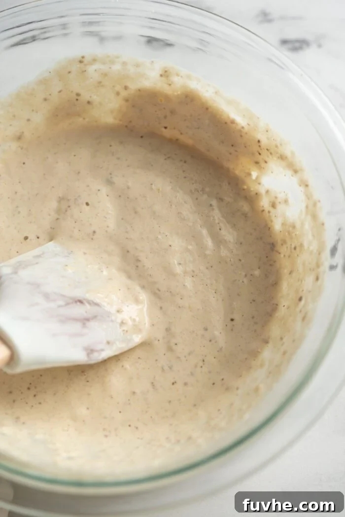 Protein-Packed Vegan Quinoa Pancakes 5 Pancake batter in a mixing bowl with a spatula.