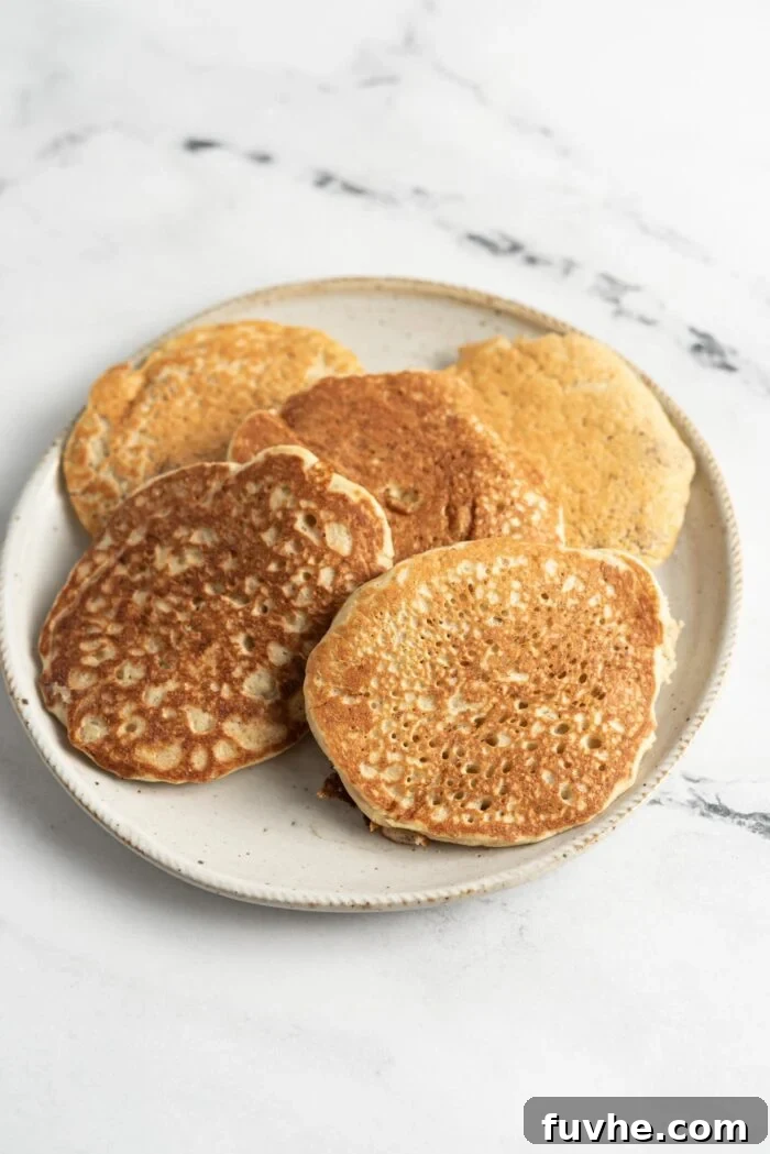 Protein-Packed Vegan Quinoa Pancakes 8 5 pancakes on a small plate on a marble surface.