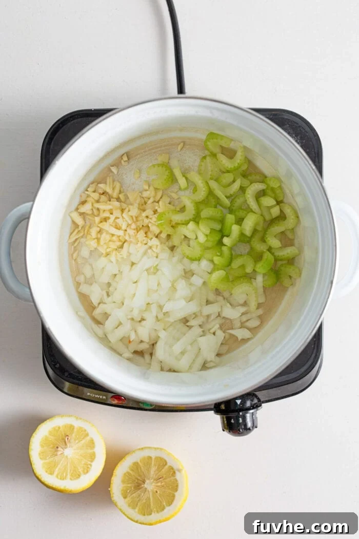 Onion, garlic and celery cooking in a soup pot.