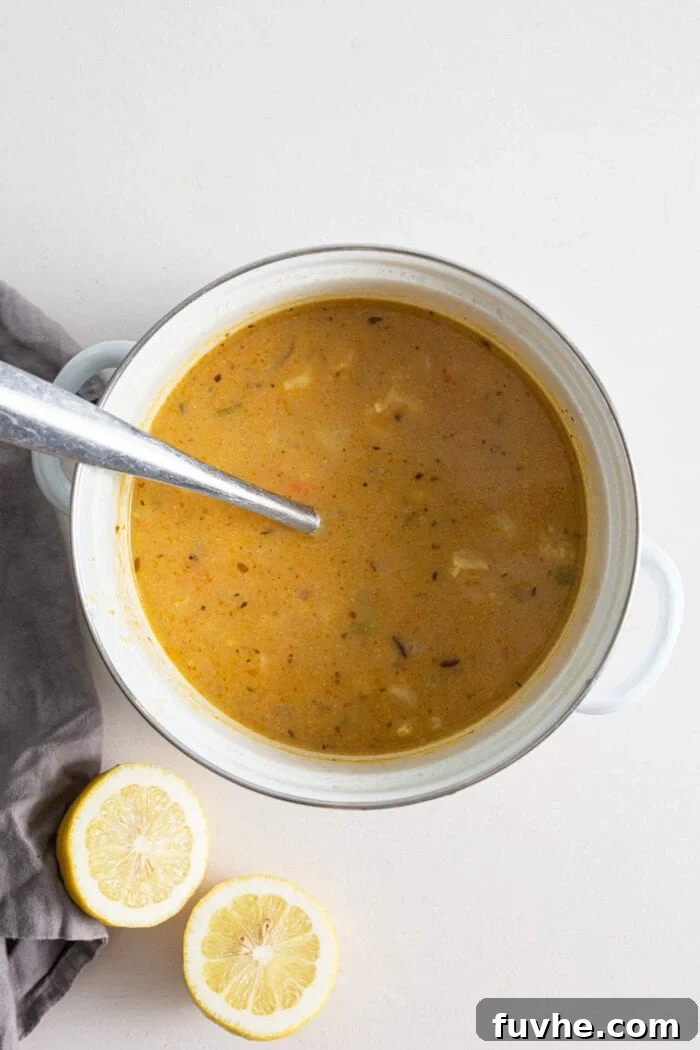 Creamy cauliflower wild rice soup in a soup pot. Ladle rests in pot.